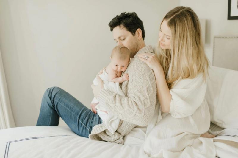 Nicole Taylor sits on the bed where she gave birth to her daughter Lily weeks after being infected with COVID-19 with her husband Sam Rubin and son August by her side. Courtesy: Lyndsey Yeomans.