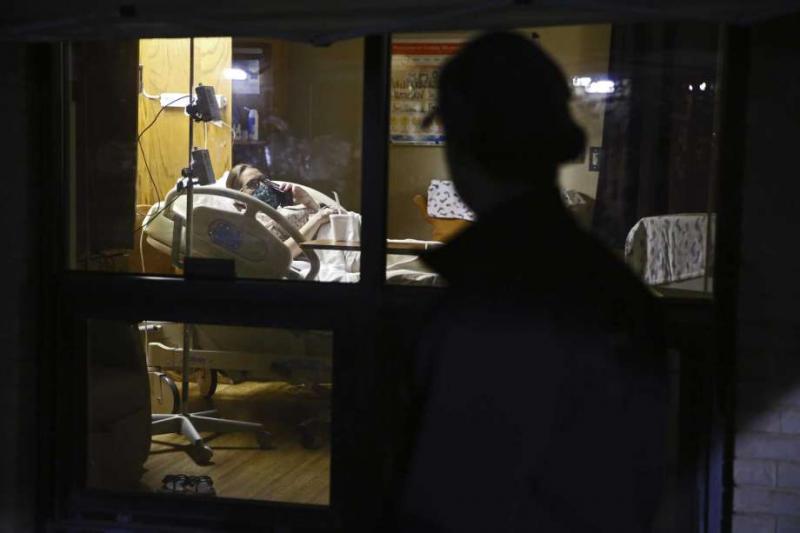 After arriving at Uvalde Memorial Hospital around 3:20 a.m. on April 13, Alex Benavidez spent the morning watching Kayla labor through the hospital room window. They talked often by phone and video calls. (Jerry Lara | Express-News)