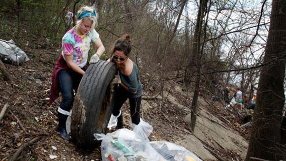 Ilsa Dewald, 19, and Chelsea Krist, 21, both from the University of Iowa, are among about 50 students cleaning up McKellar Lake through Living Lands & Waters' Alternative Spring Break. Last year the group collected 160,000 pounds of garbage from McKellar Lake in 12 days.