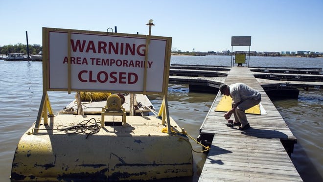April 4, 2016 - Larry Stanley, owner of Riverside Lake Marina, picks up tools from his dock after a warning sign was installed on one of his work boats at McKellar Lake Monday. The City of Memphis has closed the boat ramp at 1875 McKellar Drive, which allows access to McKellar Lake, after a major sewer line transporting wastewater to the TE Maxson Wastewater Treatment Plant that was damaged. (Yalonda M. James/The Commercial Appeal) 