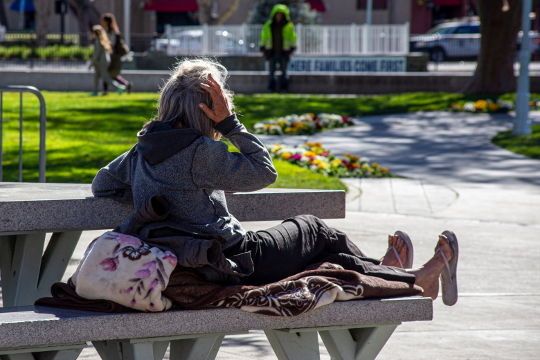 A homeless woman rests on a bench at Todos Santos Plaza in Concord, Calif., on Feb. 15, 2022. (Harika Maddala/ Bay City News)
