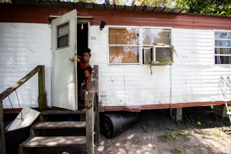 Jakeila, 9, and her little brother Nathaniel, 2, peek their heads out the door of their home in Jasper, Florida Wednesday, July 6, 2022. ALICIA DEVINE, USA TODAY NETWORK