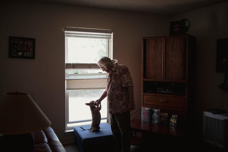 Steve Harbin pets his dog Brownie at his home in Albuquerque on June 23, 2022. Adria Malcolm/New Mexico In Depth