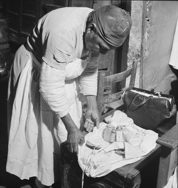 Midwife wrapping her kit to go on a call in Greene County, Georgia in the 20th century (Courtesy of Library of Congress/ Jack Delano).