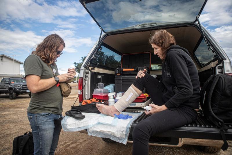 Dr. Kyle Patton bandages a sore on a patient’s leg in the back of his truck on Sept. 19, 2022 and prescribes her antibiotics. Later, test results will show that the sore is a symptom of late-stage syphilis. Photo by Larry Valenzuela, CalMatters/CatchLight Local