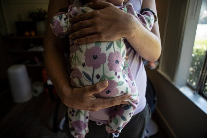 Cassidy holds her child in her apartment in Redding on Sept. 20, 2022. Earlier that day, Cassidy graduated from an intensive outpatient substance treatment program after being sober for nine months and one week. Photo by Larry Valenzuela, CalMatters/CatchLight Local.