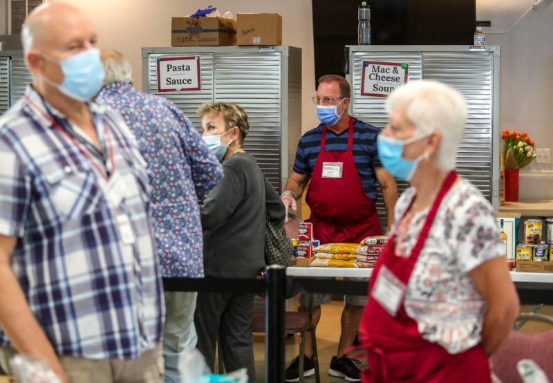 Volunteer Jeff Bergen helps a client at the Cathedral City Senior Center food bank in Cathedral City, Calif., Monday, April 25, 2022. Andy Abeyta/The Desert Sun
