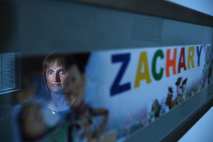 Cheryl Chafos is reflected in a framed photo in her son's bedroom. (Matt McClain/The Washington Post)
