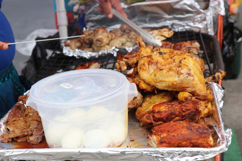 Chicken, loaded with sazón, cooks on the grill at the Guatemalan Night Market near MacArthur Park.