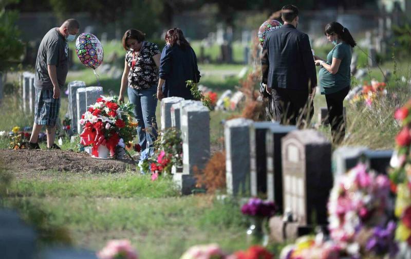 Jesse Rodriguez, left to right, Jacqueline Castillon, Chabela Vargas, Galo Gutierrez and Cynthia Gutierrez visit the graves of six members of their family at San Fernando Cemetery No. 2, on Sunday, Oct. 4, 2020. All six died from COVID-19.  Bob Owen, Staff-photographer / San Antonio Express-News