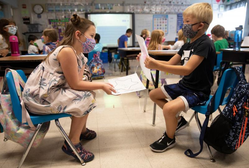 First-graders Ella Siciliano, left, and Crosley Roewer, show each other what they wish for during an assignment in Julie Fischer's class at J.F. Burns Elementary, on Aug. 31, 2021. The curriculum is part of an evidence-based program called the Character Effect developed by Beech Acres Parenting Center. Beech Acres trains the teachers on how to weave the teachings into their day, little by little. The idea is to teach social-emotional intelligence and demonstrate positive character traits. LIZ DUFOUR/THE ENQUIRER