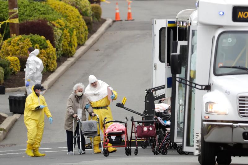 Residents from St. Josephs Senior Home are helped on to buses in Woodbridge, N.J., on March 25, 2020. More than 90 residents of the nursing home were transferred to a facility in Whippany after several testes positive for the coronavirus. Seth Wenig/AP