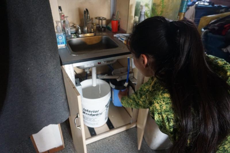 Blanche Okbaok-Garnie, the mayor of Teller, Alaska — which isn't served by water and sewer pipes — shows the Mini-PASS home sanitation system in her house. (Yereth Rosen)