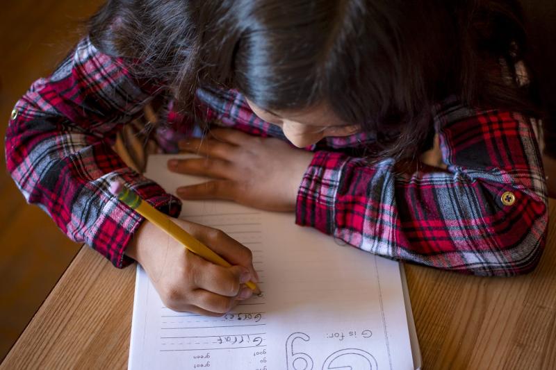 Eight-year-old Fernanda Davila works on a spelling packet at the kitchen table in her Phoenix home on March 8, 2022. MONICA D. SPENCER/THE REPUBLIC