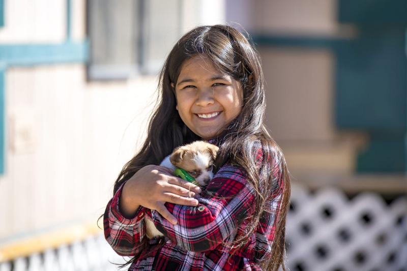 Eight-year-old Fernanda Davila holds her puppy, Dolores, outside her Phoenix home on March 8, 2022. MONICA D. SPENCER/THE REPUBLIC