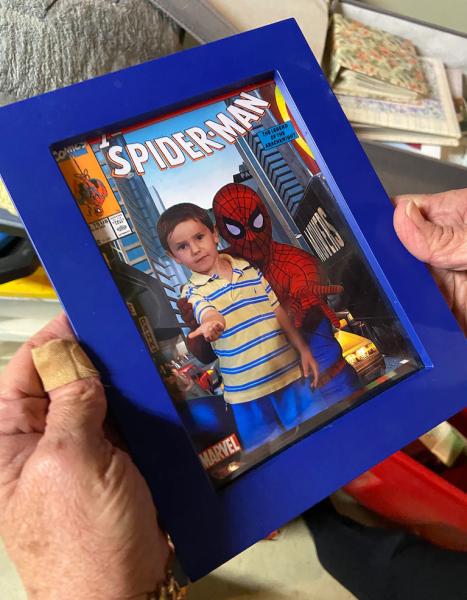 Lisa Rowe holds a photo of her son at 3, posing with Spider-Man during a trip to Universal Studios. (Family photo)