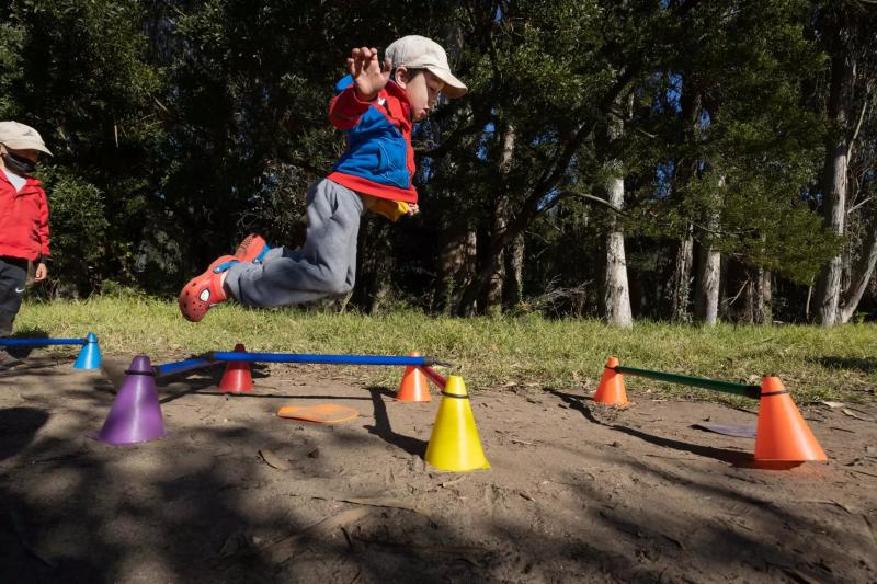A child leaps during an outdoor activity next to San Francisco’s Stern Grove at Baby Steps on Friday, Nov. 18, 2022.(Paul Kuroda / For The San Diego Union-Tribune)