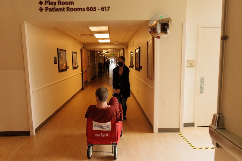 At 6 feet, Jack is taller than most little red wagon riders, but he climbed in and got his mom to pull him in the hospital corridor at Mary Bridge. (Erika Schultz / The Seattle Times)