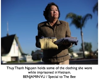 Thuy Thanh Nguyen holds some of the clothing she wore while imprisoned in Vietnam.